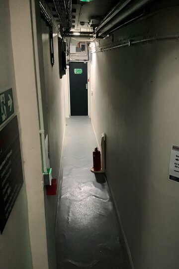 An empty, dimly lit narrow corridor