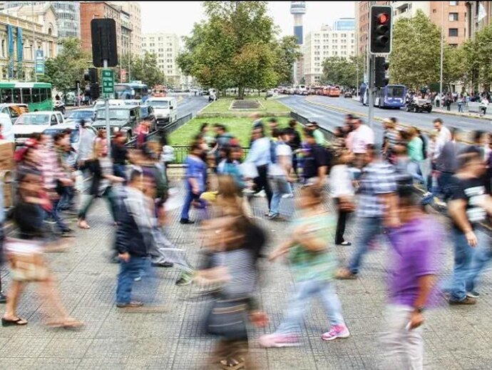 time lapse blurred photo of people walking around a busy pedestrianised square