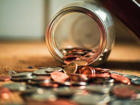 Jar tipped over with copper coins spilling out