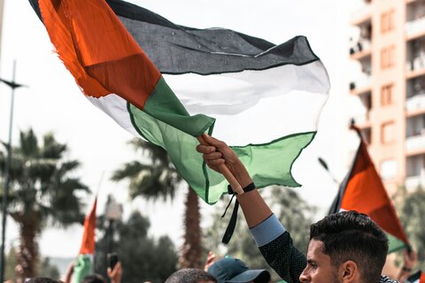 A man holding aloft a Palestinian flag during a protest